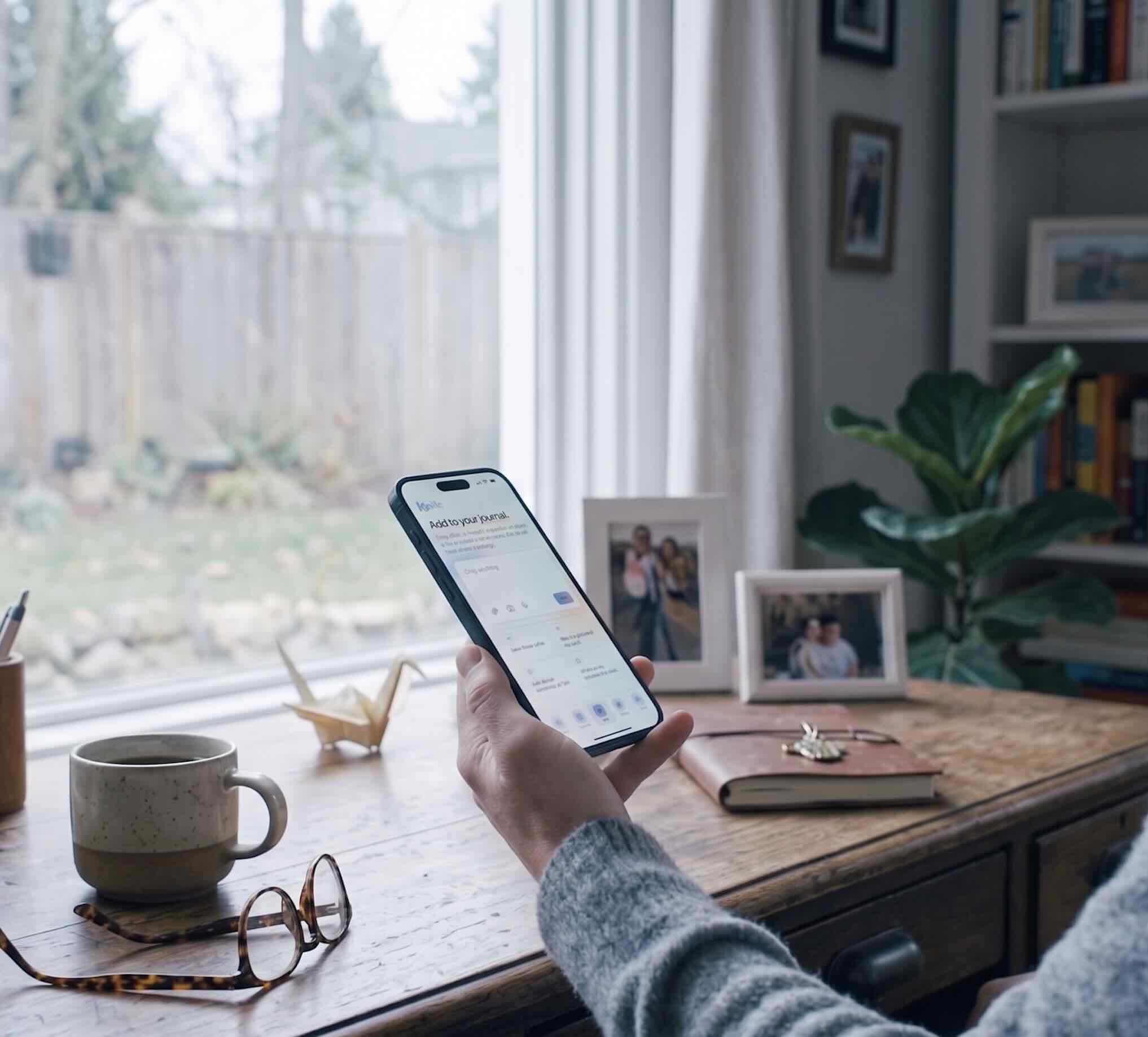 A family member using KinLife on their phone at a sunlit desk